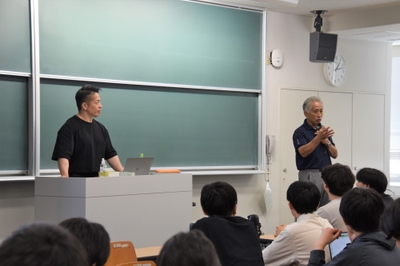 岡田教授を紹介する梅田教授