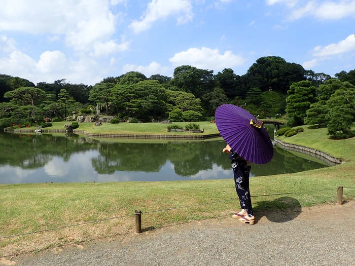 夏の庭園を和傘で散策する来園者(昨年の六義園のようす)