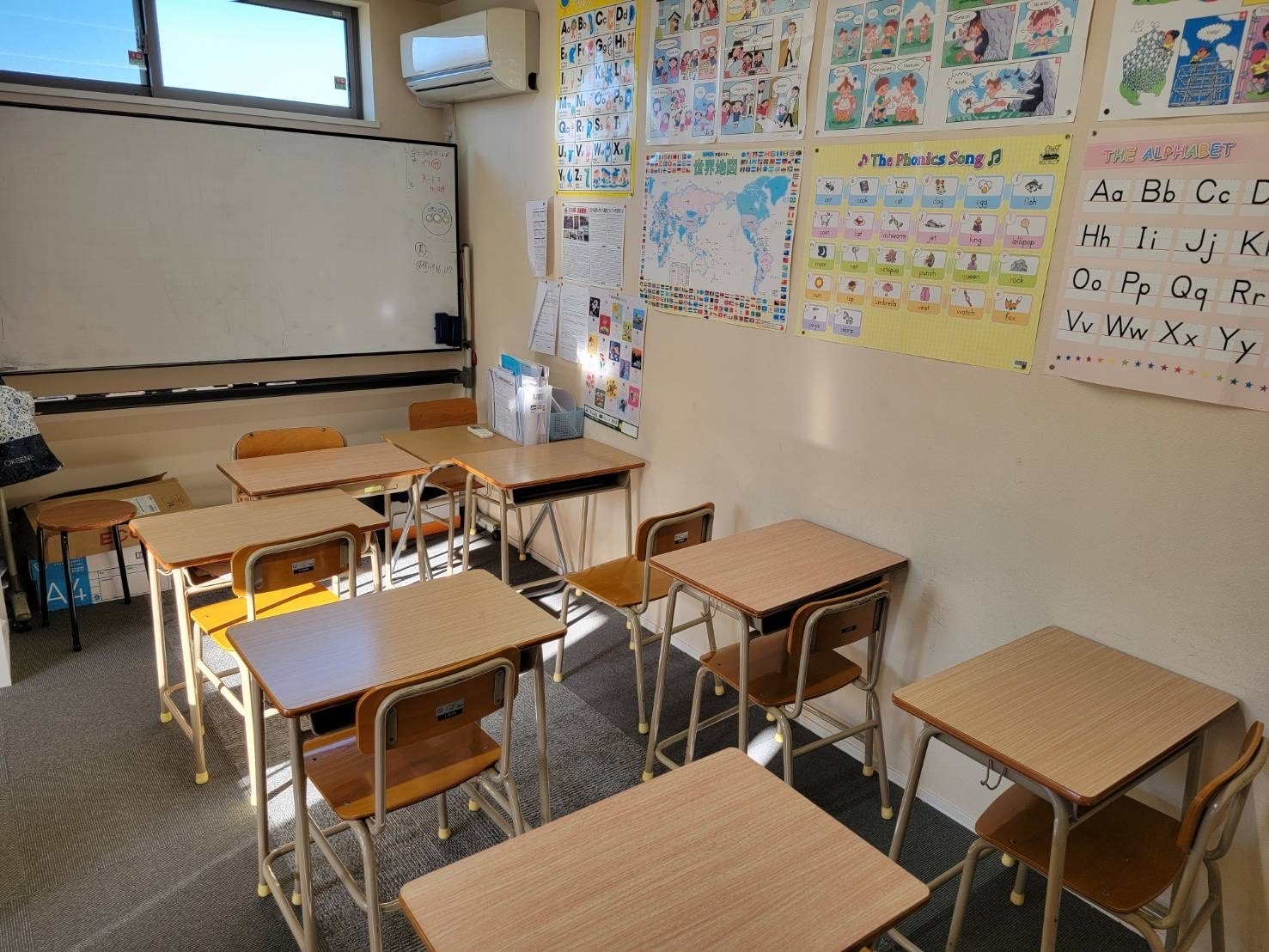 フリースクール滝野川高等学院浦和美園校の教室内観。机と椅子が配置され、英語学習教材が壁に掲示されている