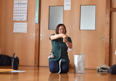 ヨガ後のお茶会で、膝の健康について地域住民と対話する看護師。「病院へ行くほどではない」と感じていた不安にも耳を傾けました。
