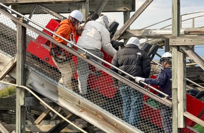 アトラクションが緊急停止し、降車の補助および救助を行う様子