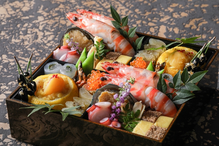 ▲壱の段:特製の栗きんとんや、干し葡萄がアクセントになった松風焼き、長時間真空調理することでふっくらと柔らかく仕上げた蝦夷鮑の柔らか煮、鉄板焼き「匠」の自家製ポン酢ジュレを使用した真鯛の昆布締めロールなどが凝縮された和風の壱の段