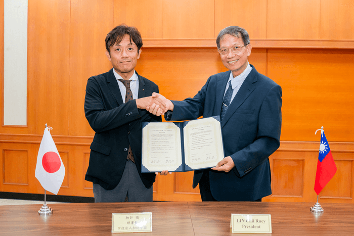 協定書を手に握手する加計理事長(左)と林学長(右)