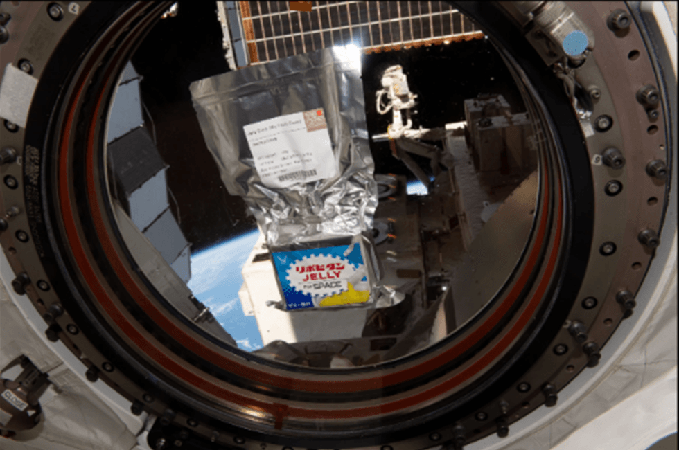 地球を背景に宇宙でプカプカと浮かぶ「リポビタンJELLY FOR SPACE」提供:JAXA/NASA