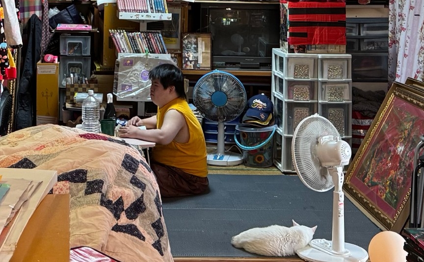 制作活動に取り組む小波津有希さんの日常の様子。白い猫も一緒の作業場風景