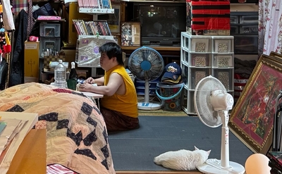 制作活動に取り組む小波津有希さんの日常の様子。白い猫も一緒の作業場風景