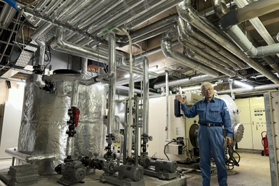 温泉廃熱利用システムの見学に応じる神島