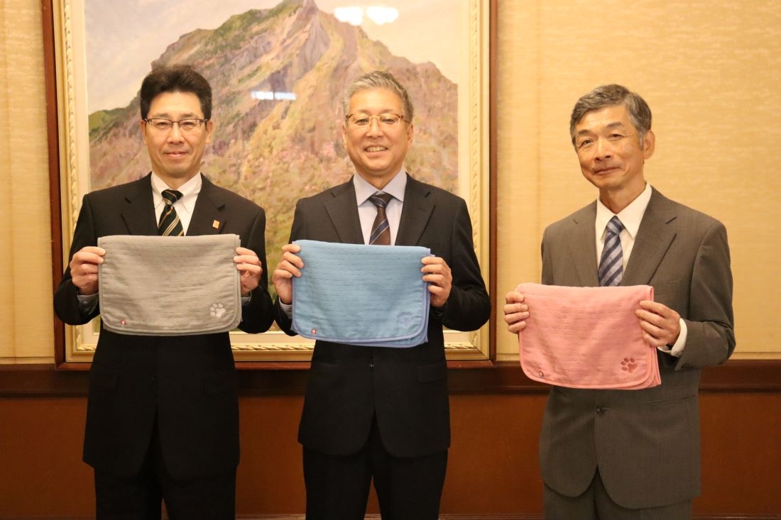 共同開発したペット用タオルを手にする(左から)菅副知事、福岡部長、村田副学部長
