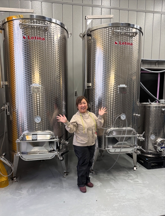 小さな身体での発酵管理は一苦労（醸造タンクの前で）