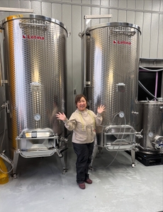 小さな身体での発酵管理は一苦労（醸造タンクの前で）