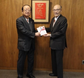 校友会の森会長（右）から目録を受け取る立花前理事長