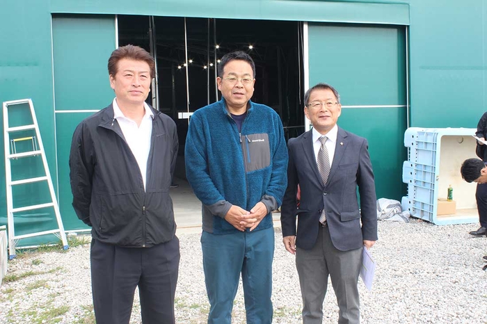 試験養殖施設の前で(左から)金谷組合長、山本准教授、河野町長