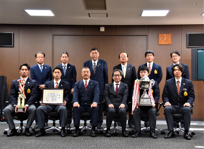 立花理事長(後列右から3人目)と小原学長(同4人目)に優勝報告したアメフト部の皆さん