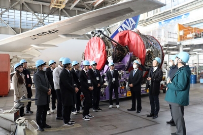 格納庫で担当者の説明に聞き入る学生たち