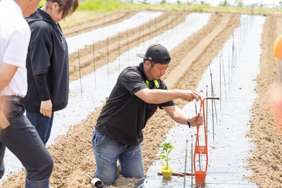穴を空ける作業を実演する生産者の山田さん