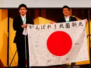 北薗選手(左)にメッセージ入り国旗を渡す
