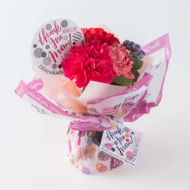 SHOGO SEKINE氏オリジナルイラストの ラッピングペーパーを用いた ブーケ「シュシュ・フルール」 税込3,780円（本体価格3,500円） 税込2,500円（本体価格2,315円） 2タイプ展開 ※画像は2,500円のタイプ 展開期間：5月9日（火）～5月14日（日）