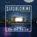 夜の海辺にたたずむ映画館