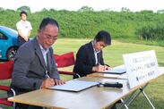 協定書に署名する太田市長と山井代表取締役社長