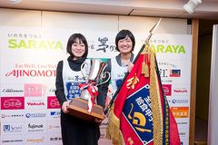 第11回全国学校給食甲子園で優勝旗と優勝カップを手にする北海道足寄町学校給食センターの栄養教諭・小森 美優さん(右)と調理員・廣田 裕美さん(左)