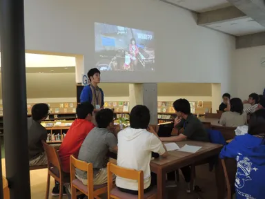 生徒の前でプレゼンを行う学生