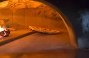ピッツァ窯で焼き上げるピザ