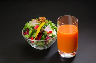 有機人参のコールドプレスジュースと新鮮な生野菜サラダ