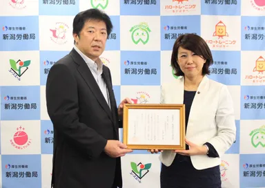 「くるみん認定通知書交付式」 写真左：厚生労働省 新潟労働局  楪葉局長 / 写真右：亀田製菓株式会社　総務部　内山マネージャー