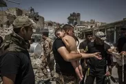 世界報道写真コンテスト　一般ニュースの部　組写真1位　イヴォール・プリケット（アイルランド） ニューヨークタイムズに提供、2017年7月12日　モスルをめぐる戦闘：イラク軍特殊部隊の兵士によって手当てをうける身元不明の男の子。