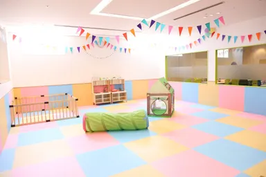 キッズスペースとガラス越しに隣あう執務スペース(ママスクエア)