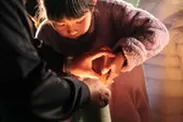 竹灯籠に点火する子供
