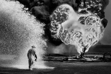 Chemical sprays protect this fire fighter against the heat of the flames.　Greater Burhan, after the Gulf War. Kuwait, 1991.(C) Sebastiao Salgado