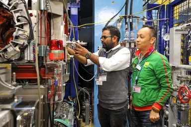 【4日目】ミュオンS1での実習の様子。試料を取り付けた冷凍機をS1装置に挿入。