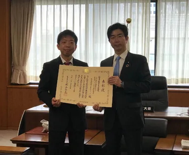 表彰状授与の様子(右：牧原経済産業副大臣　左：リッジアイ代表取締役社長 柳原)