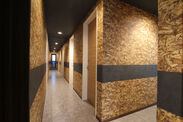 物件内部の廊下には木材の小片を圧縮して作るパーティクルボード調の壁紙を起用