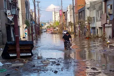 たまたま友人が撮ってくれた人吉のメインストリートで自転車をこぐ中村