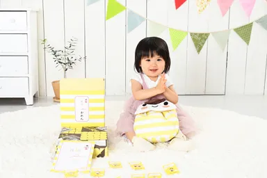 「くずもっちゃん」リュックがお祝いをもちあげます。