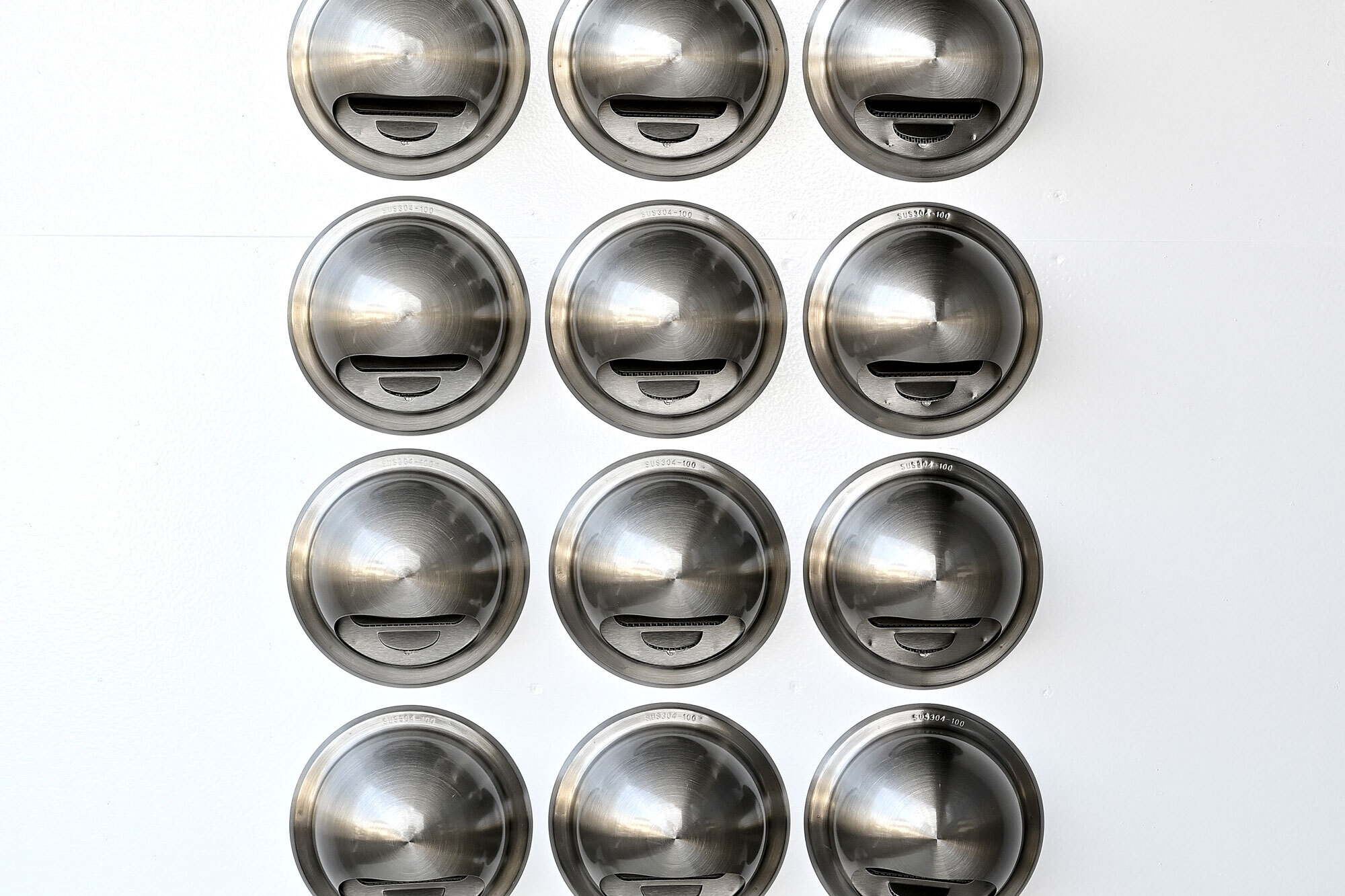 換気扇を多数配置したユニークなデザインの壁