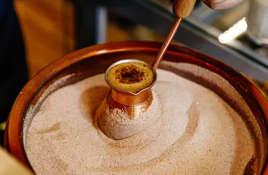 銅と真鍮製の長い柄のついた小鍋「ジェズヴェ」を使ったトルココーヒーの伝統的な作り方の様子