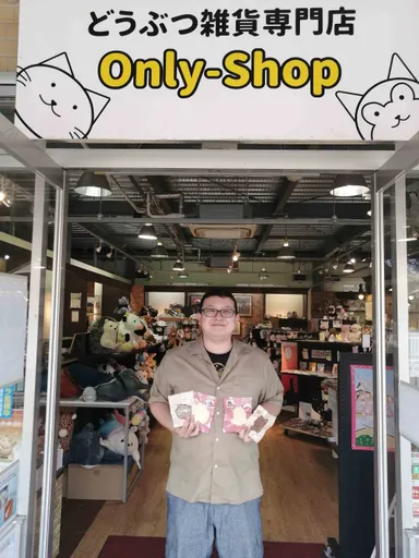 お店の入り口でクッキーを持った代表山口