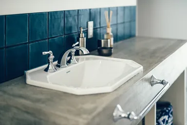 間口の狭い空間を有効利用するため廊下に設けたモルタル仕上げの洗面台。