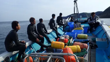 一隻の船に乗り込み漁に出る海士