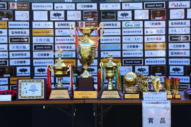 たくさんのトロフィーとスポンサーボード