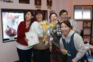 3月10日プレオープンに集まる友人と清水 則子(写真：中央色紙と花束を持つ女性)