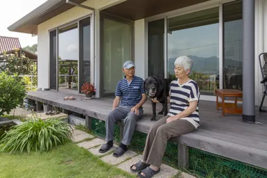 ウッドデッキで家族の時間を過ごす、吉田さんご夫妻とタローくん