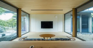 小上がりの畳コーナーから南北の庭に囲まれたリビングを望む