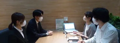新聞社での経験を生かして現在取り組んでいる学生記者の活動で明治大学法律相談部（左）へ取材している様子（本人は右奥）