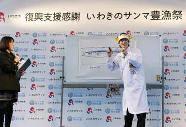 サンマの絵を描いて会場を盛り上げるさかなクン