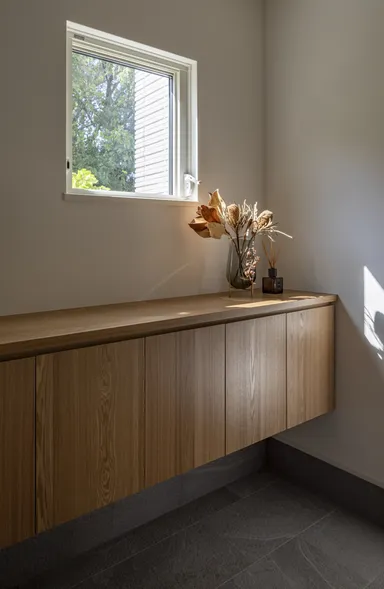 西側の森の緑を切り取る玄関収納の上の小窓