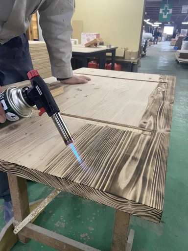 杉材の天板をバーナー加工している様子